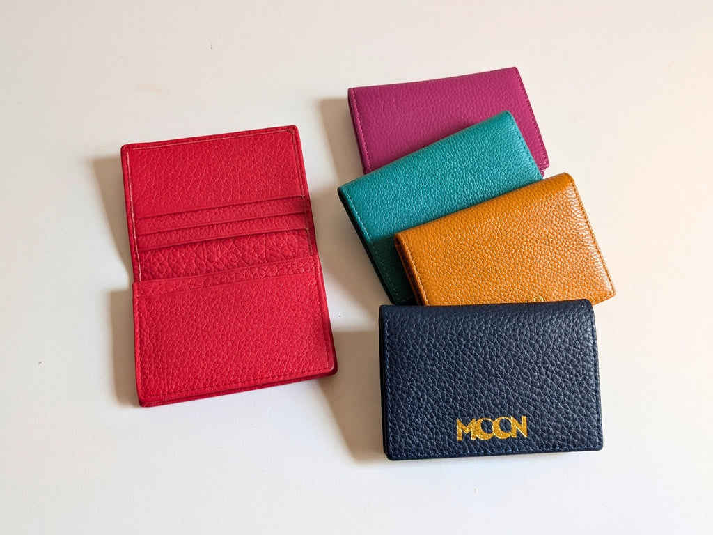 Five colorful wallets on a light background