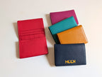 Five colorful wallets on a light background