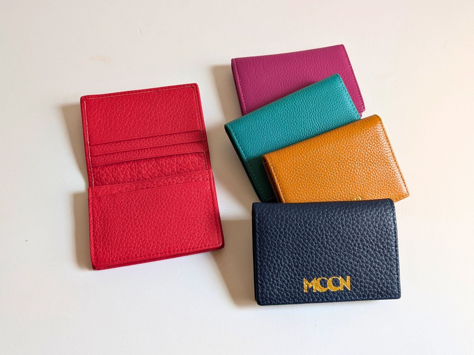 Five colorful wallets on a light background