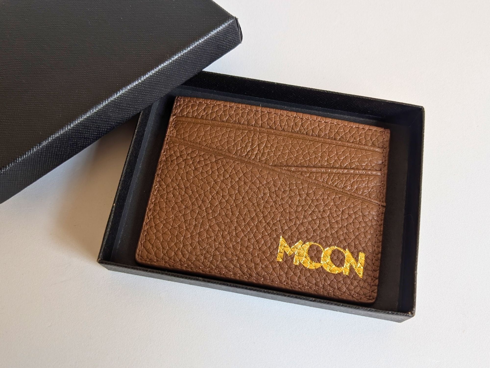 Brown leather cardholder with custom corporate logo branding in gold on a white background