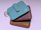 Three small leather bags with custom names and branding embossing in gold, silver and blind.