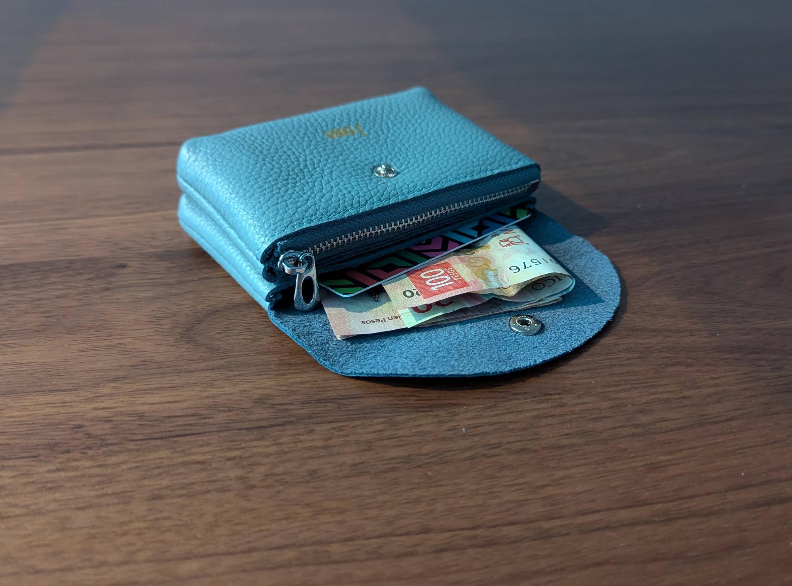 Blue wallet with money on a wooden surface