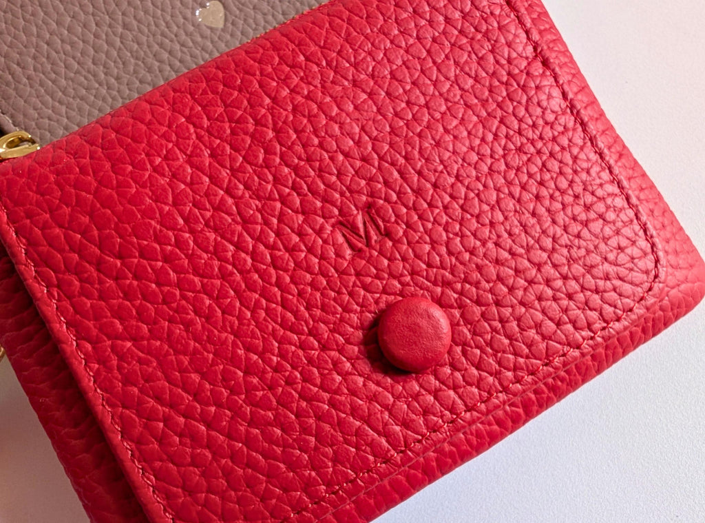 Red textured wallet with a button on a light background