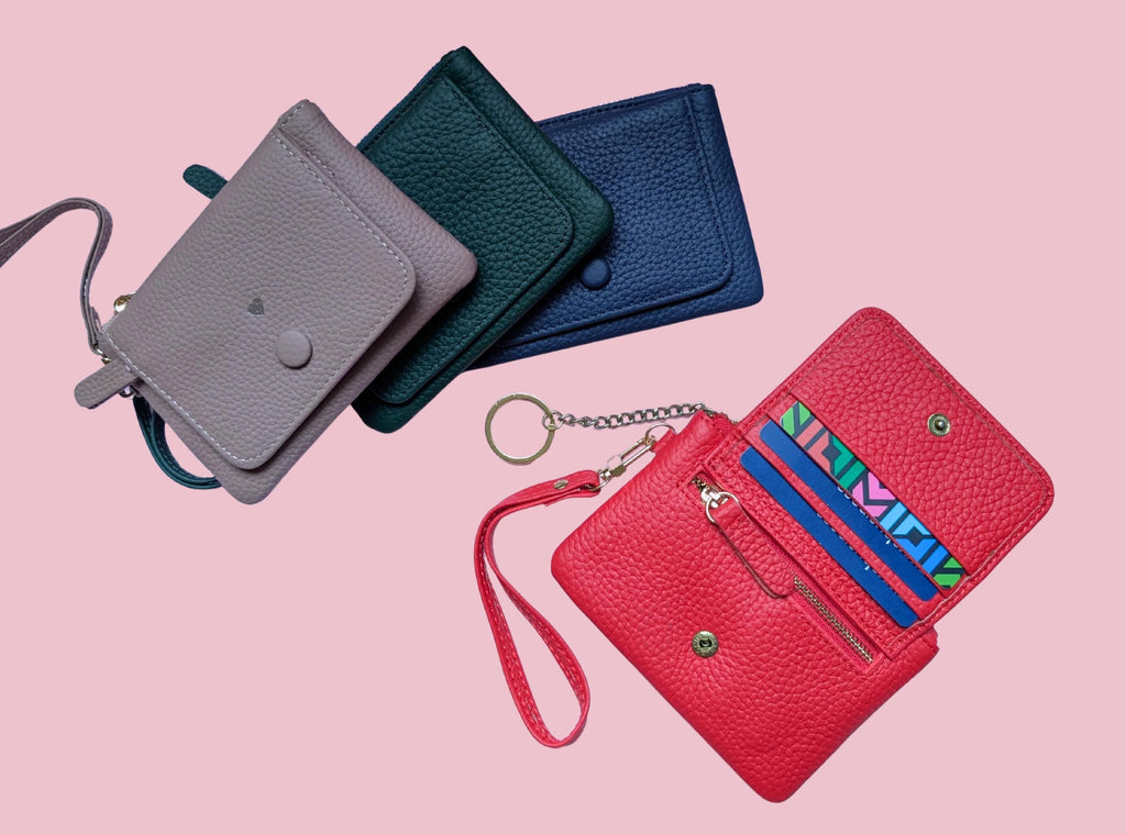 Set of colorful wallets on a pink background