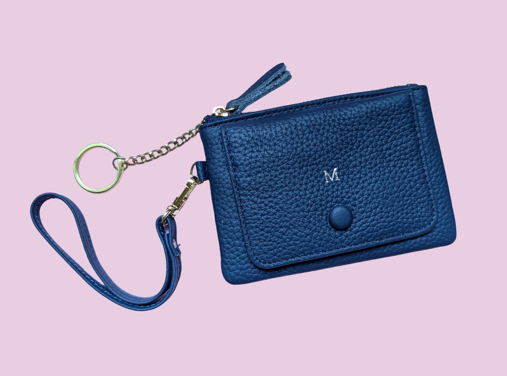 Blue wallet with chain strap on a pink background