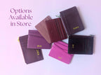 Collection of leather card holders with initials on a light pink background