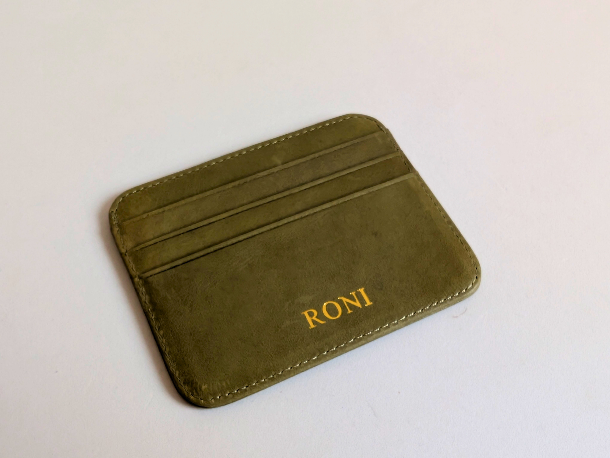 Green cardholder with  custom gold engraving on a white background