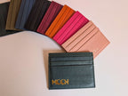 Collection of colorful leather card holders with a black one featuring custom logo embossed in gold. 