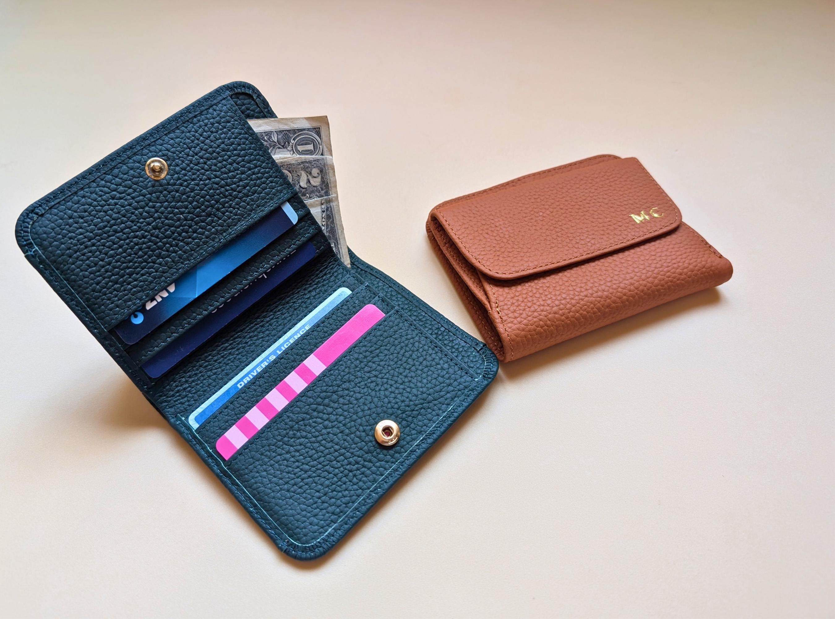 Blue leather wallet with card slots and a brown wallet on a light background