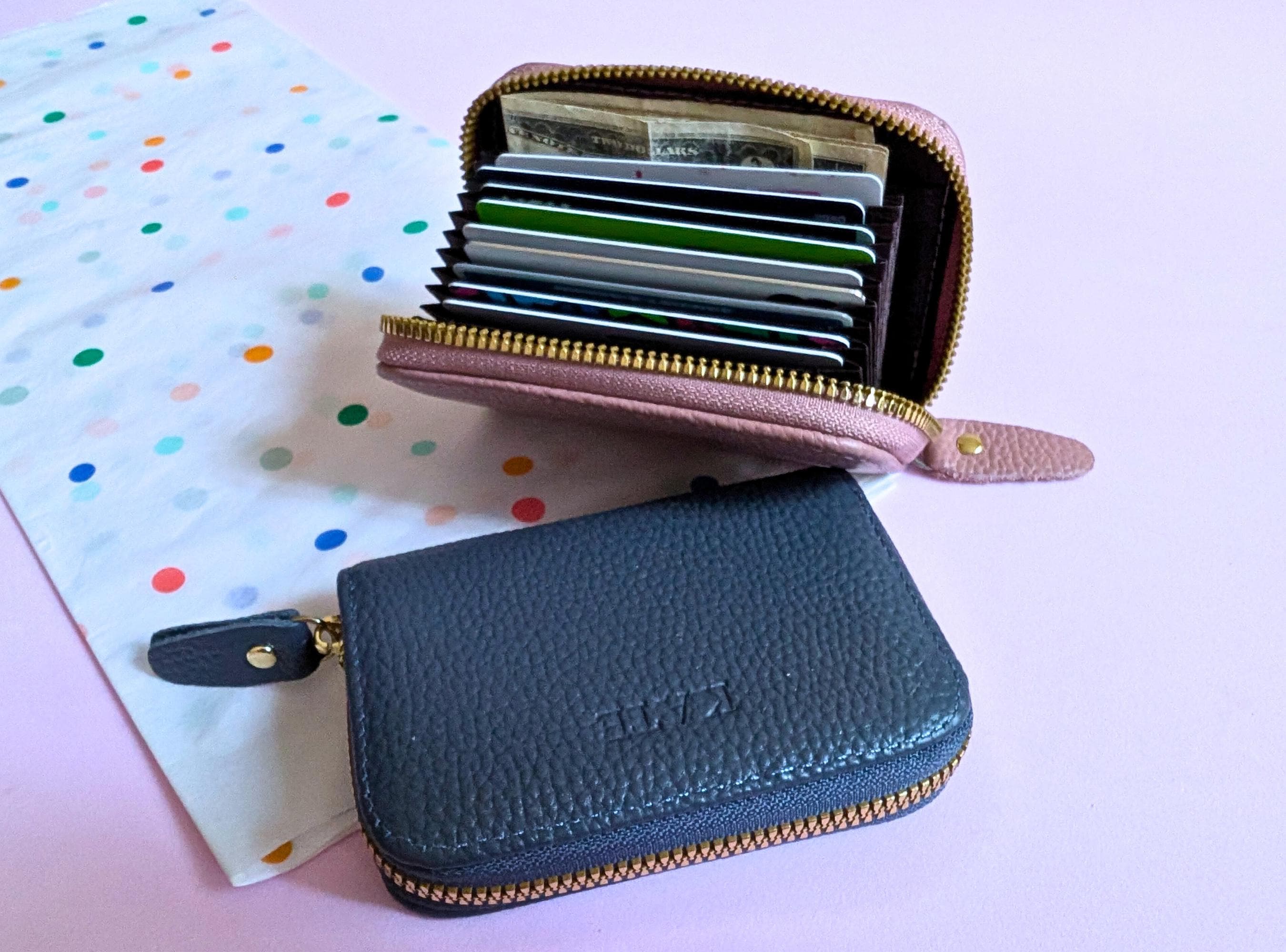 Blue wallet with a pink interior showing cards on a polka dot background